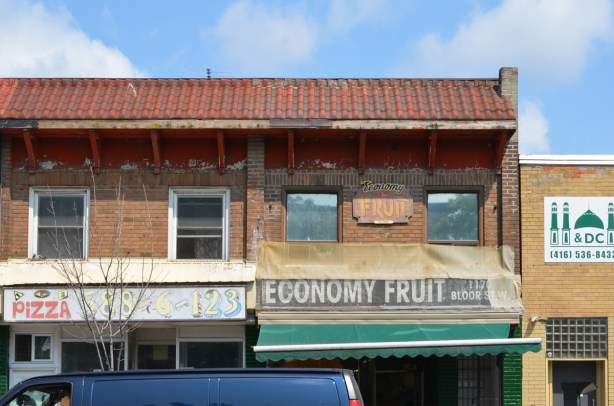 top of two storefronts, Economy fruit, and a pizza place