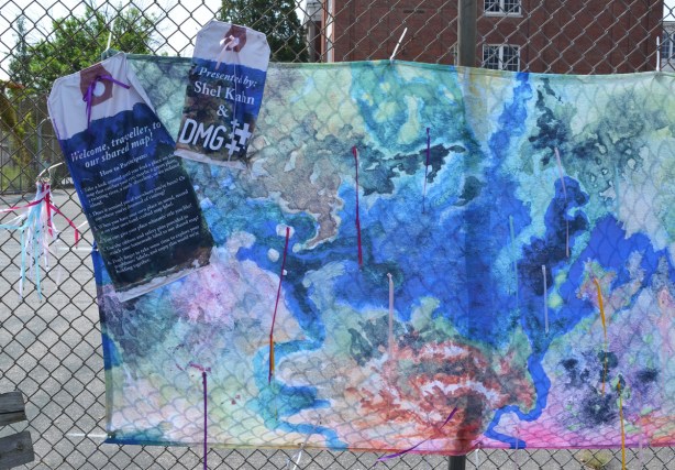 an interactive art installation involving maps, on a fence outside Bloordale Collegiate