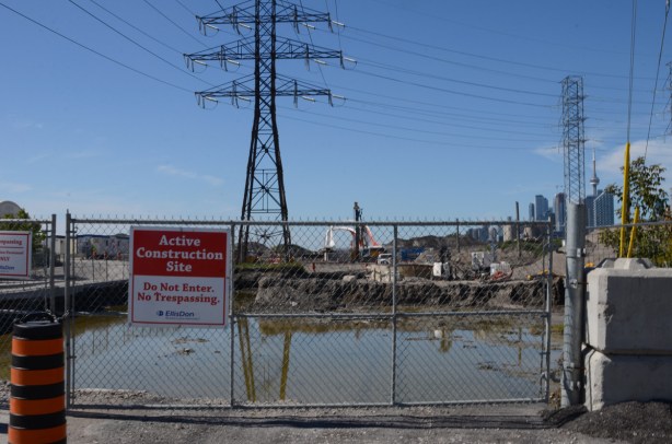 end of Commissioners Road, chainlink fence, road taken up, Toronto skyline behind