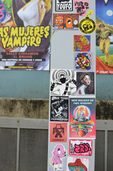 paste platz, wheatpaste papers on a wall, stickers on a beam in front of larger posters