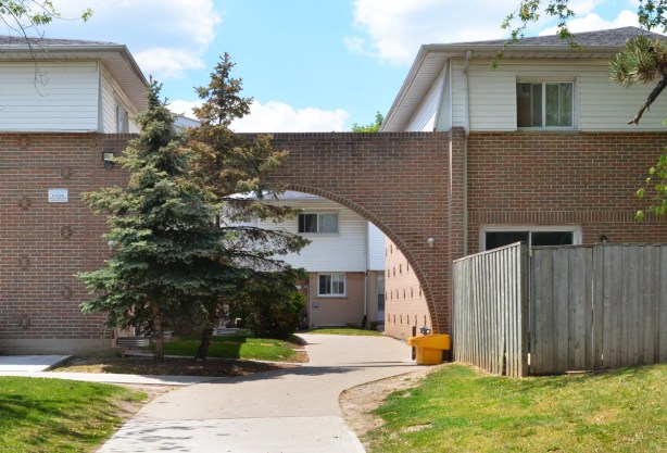 rounded arch over the sidewalk leading into a residential development