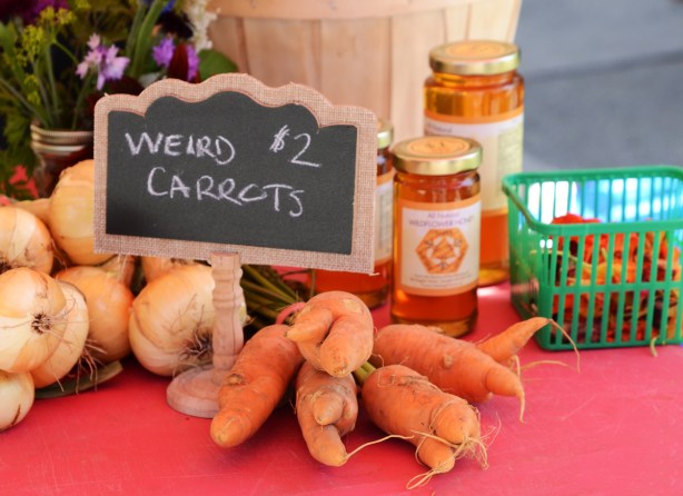 table at farmer's market, of weird shaped carrots for 2 dollars a bunch, also jars of honey
