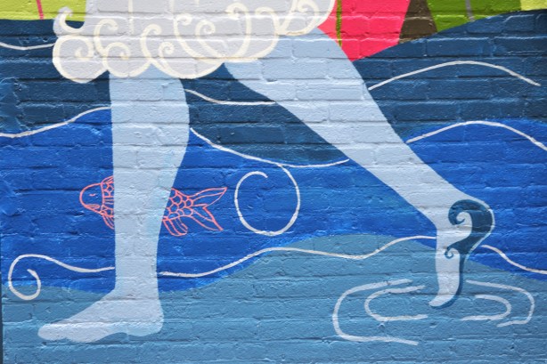 part of mural, pale blue legs and bare feet walking in swirling water