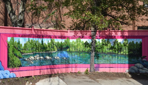 on a wood fence in an alley, a lake scene mural with pink border