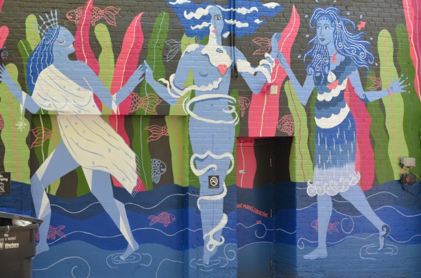 three water women mural on a wall 