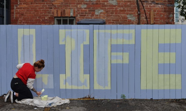 the word life painted on a fence white letters on blue background