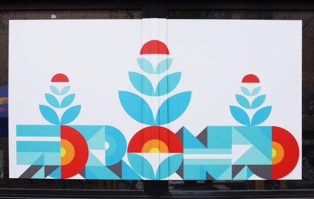 image on display at outdoor pop-up gallery, St. Patricks market, by Peru 143, stylized text says Toronto