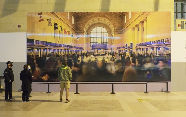 a few people standing in front of an image called house of baby, a collage of people who were enslaved by the Baby family all gathered in Union Station