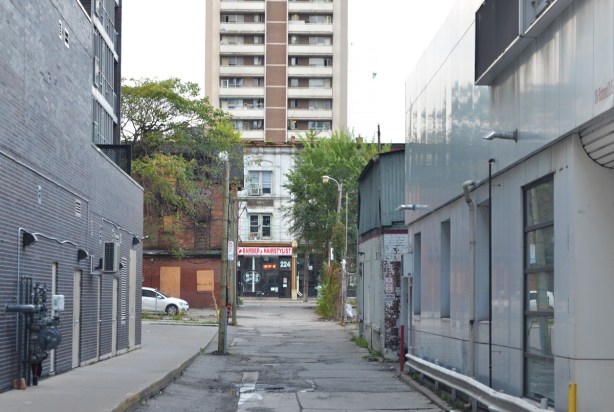 looking north on McFarrens Lane from Richomnd Steet, to the babrber and hairstylist shop on Queen. Tall apartment building behind that