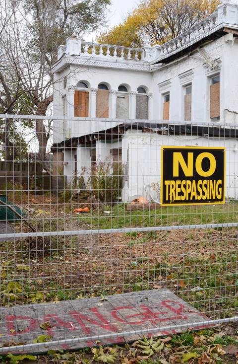no trespassing sign on metal construction fence