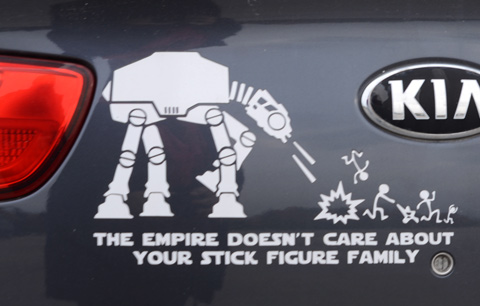 stickers on the back of a dark coloured car, robots shooting at stick figures, The Empire Doesn't Care about your stick figure family
