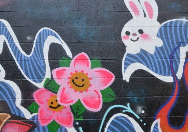 pink smiling flowers and a white smiling rabbit in a mural
