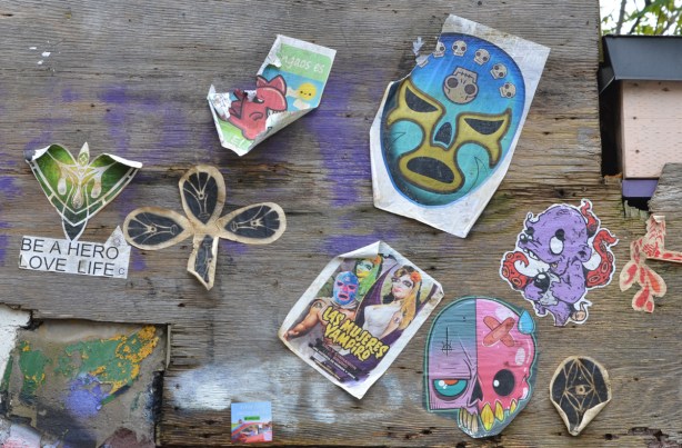 stickers on plywood hoardings, outside, mujeres vampiros, 