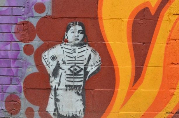 street art black and white indigenous girl in first nations clothing, black and white stencil