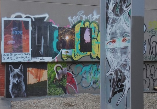 wall of paper poster pasteups, with a jumbleface foto collage of eyes 