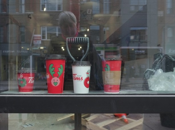 a line of Tims cups on a window ledge inside a store being renovated