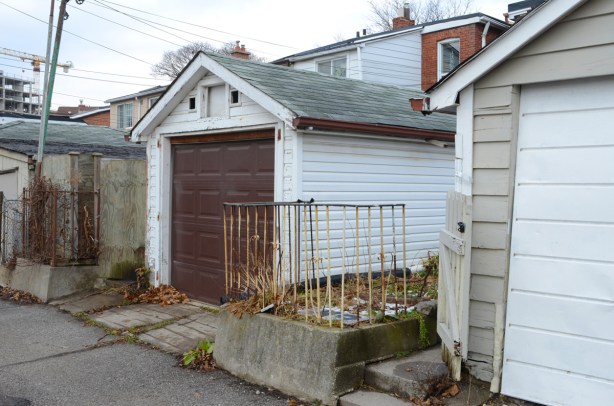 old rusty railing between garages in an alley