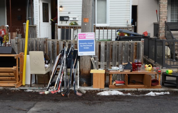 preparing for a sidewalk sale, including a sign that says amenity closed because of covid 19 