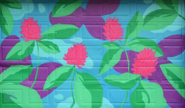 mural by Claire Browne on a garage door in a n alley, pink clover flowers with green leaves on a 