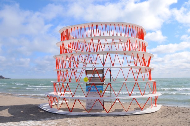 on the waterfront, beach, with lake behind, an art installation. 
