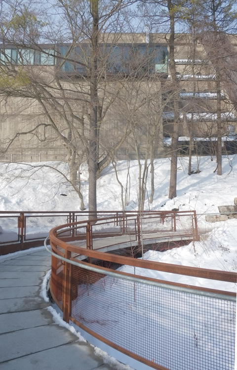 curved walkway down the side of a ravine beside Scarborough campus concrete buildings built in the 1960s, winter