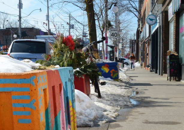 painted planters on the sidewalk on Gerrard St., in the winter with some snow