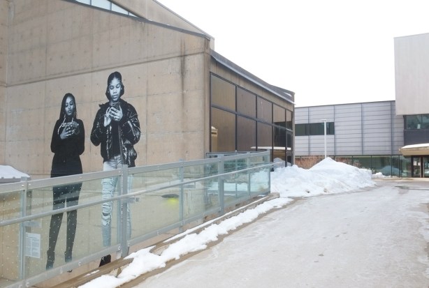 more than lifesized black and white pictures of two women on exterior concrete wall