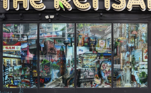 window of the Kensary cannabis store in Kensington, full of Toronto landmarks 