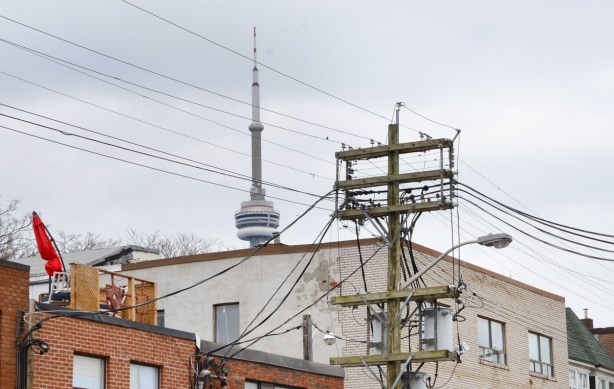 CN Tower in background, large hydro wood structure in foreground, view from Kensington 