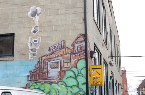 in Graffiti Alley, a lovebot pasteup up hgh, love bot and a bunch of balloons