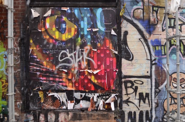 paper collage face with yellow eye,slightly peeling at the edges