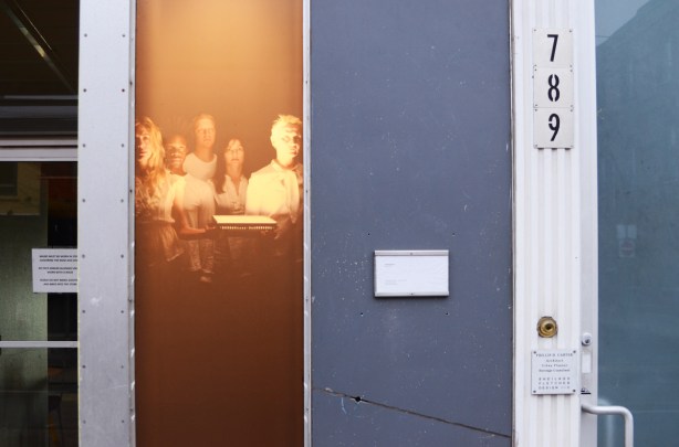 photograph on exterior of store, group of people standing together, number 789 Queen West is next door 