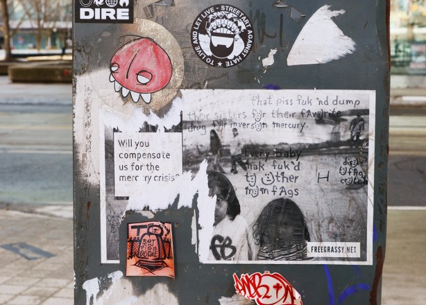 posters and graffiti on a metal box