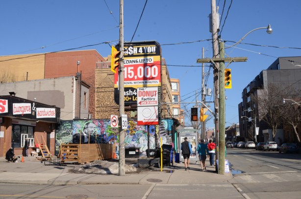 intersection on Queen East with billboard, mural, traffic lights, sidewalk, pedestrians, 