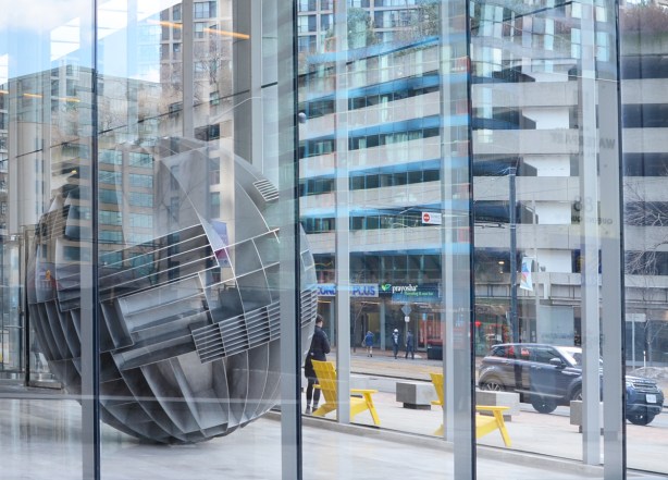 large metal spherical shaped sculpture in the glass surrounded lobby of rbc waterpark building on Queens Quay