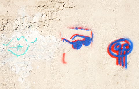 small graffiti on a white concrete wall, blue lips, dark blue sunglasses stencil, 