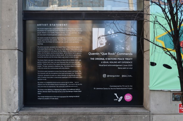 on a wall beside a mural, words that are the artist statement for the mural, also a picture of the artist, Quentin Commanda, 