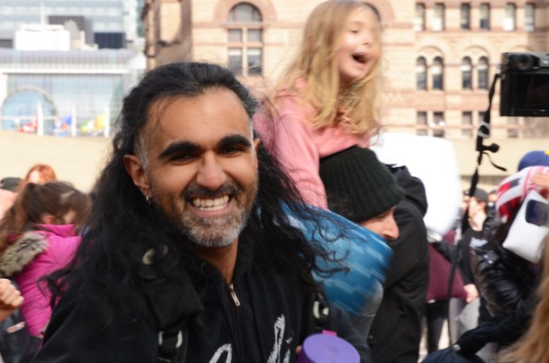 girl on shoulders of another person, laughing, man with long hair in the foreground
