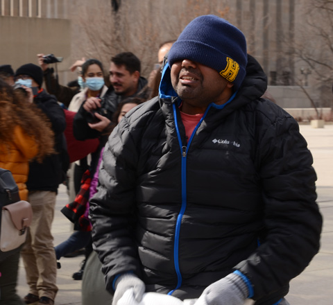 people participating in pillow at nathan phillips square, outdoors, fighting with pillows, man with his toque over his eyes