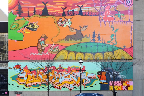 large mural with First Nations themes, painted by Quentin Commanda, outdoor scene, butterfly, bear in pink water, fish, turtle island, moose, orange grass, sunset or sunrise sky, woman sitting, 