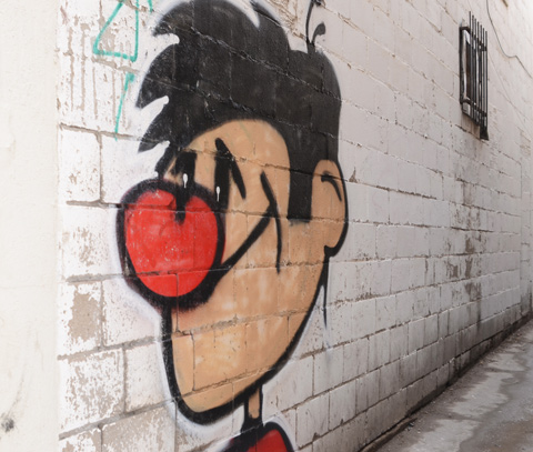graffiti of a cartoon like young man with a big red nose