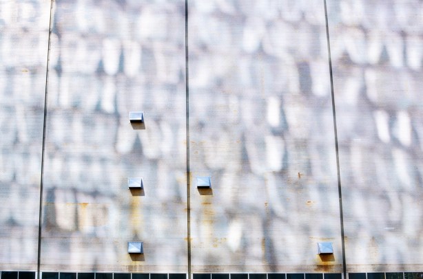 reflected light against a grey exterior wall, with 5 small vents