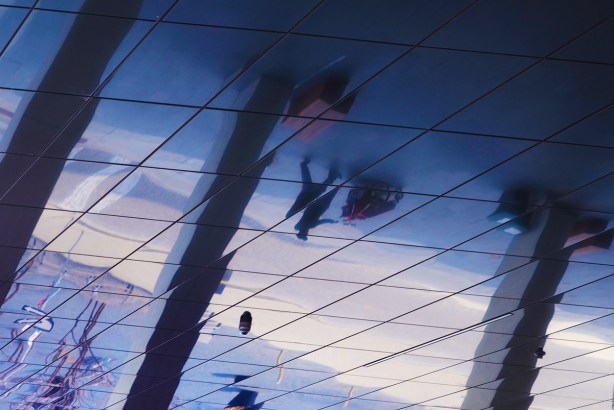 reflections of a street scene in a reflective ceiling, exterior, over the entrance to a building