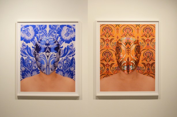 two pictures on a gallery wall, embroidered masks that blend in with their background, one in blues and the other in reds, golds, and orange, by Chun Hua Catherine Dong 