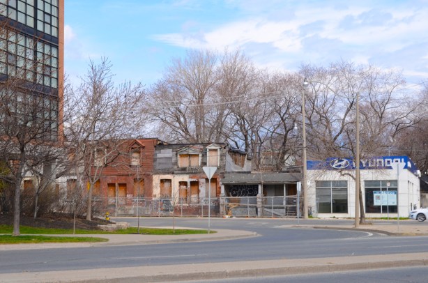 a small hyundai dealership, now empty, at the end of a row of empty and boarded up houses on Broadview