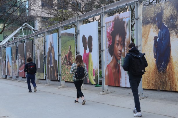 people walking past, on sidewalk, outdoor exhibit, portraits of black people, King St West, by Tyler Mitchell