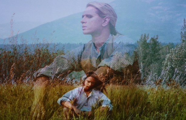 2 images from a video, during a fade in and fade out, person sitting in long grass with mountains in the background 