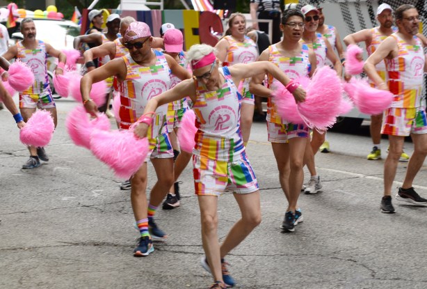 group dancing, choreography, with pink puffs in each hand, practising before the pride parade