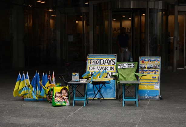 Ukrainian flags for sale, other signs re war in Ukraine, on corner of Yonge & Bloor