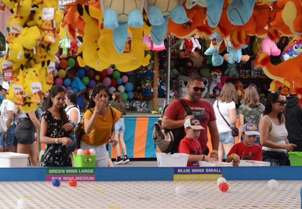 people throwing wiffle balls, ball toss game, cne midway